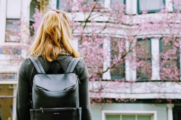 College student with her back to us wearing backpack