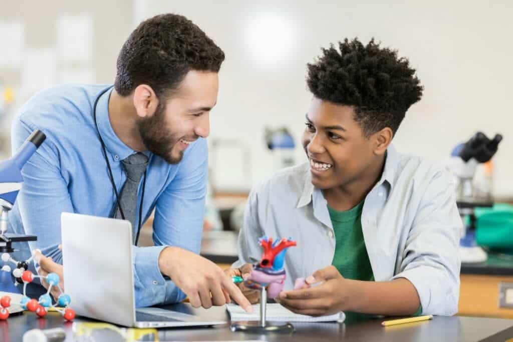 male teacher helping a male student