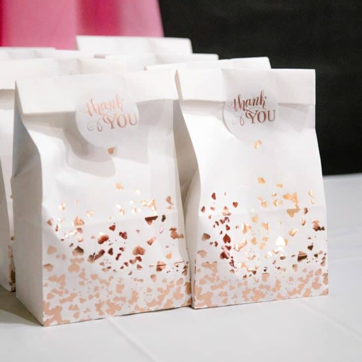 sweet 16 party favor ideas in a white gift bag with rose gold detailing and a sticker that says Thank You