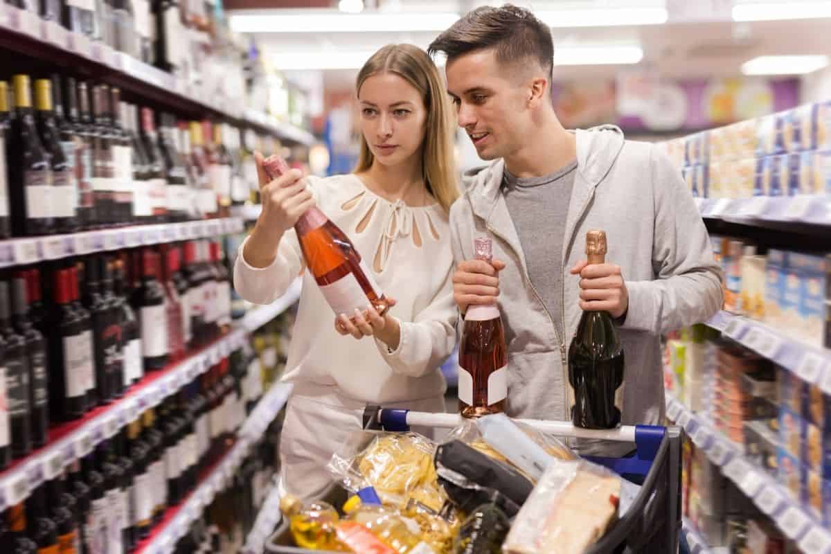 couple picking out wine and appetizers at the grocery