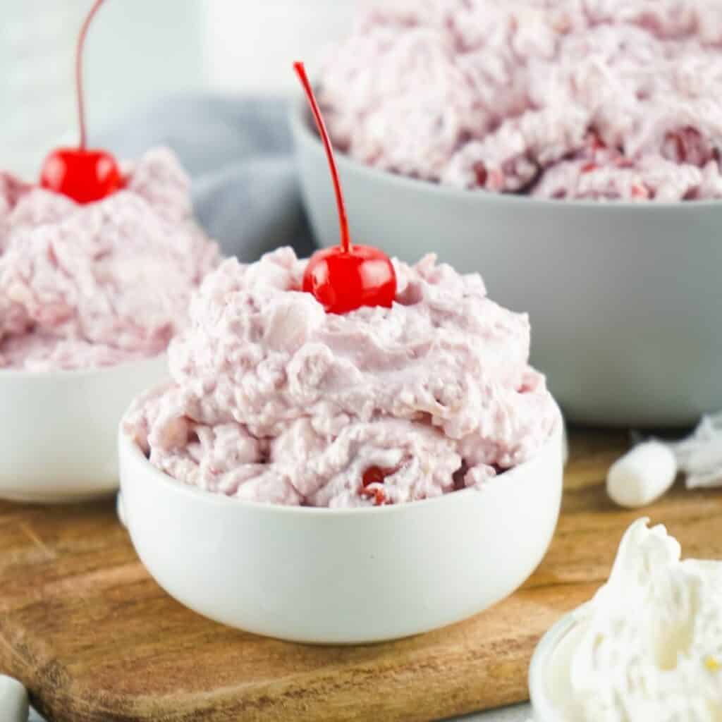 No Bake Cherry Fluff Salad Recipe in a bowl with a cherry on top