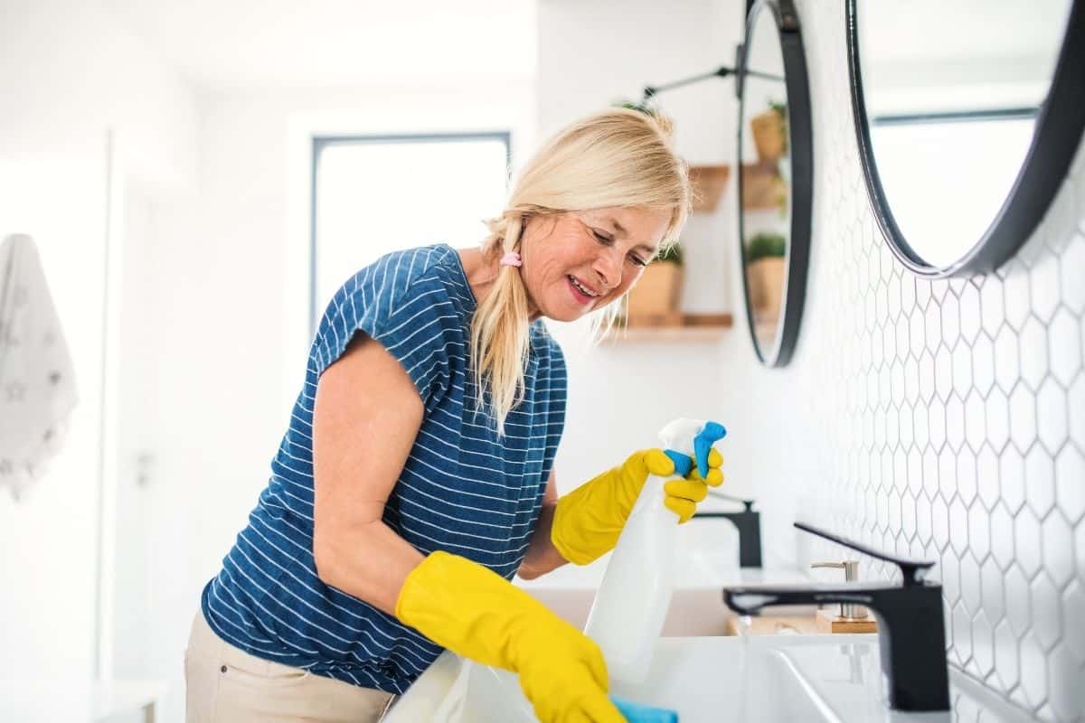 woman cleaning a bathroom sink