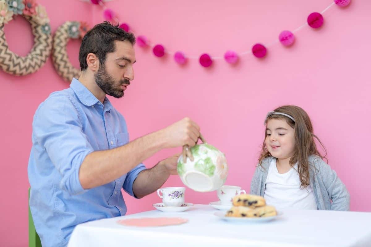 dad playing tea party with his daughter