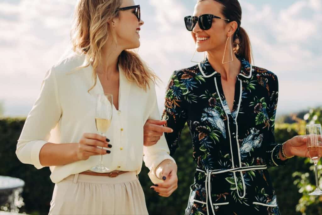 2 friends walking with a glass of wine each