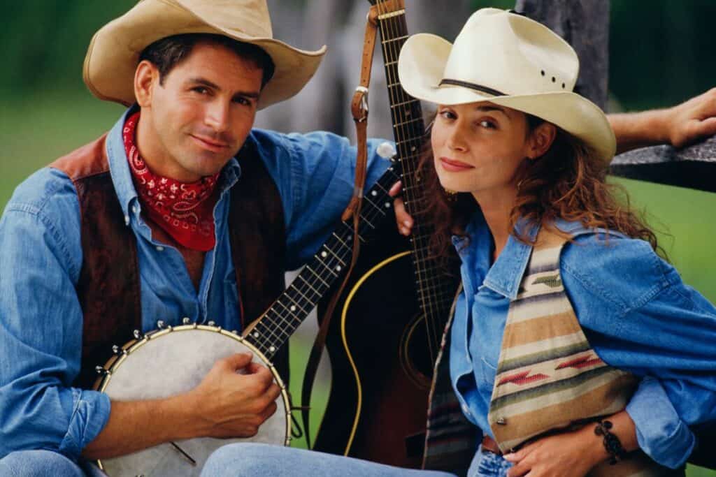 couple in western clothing and a guitar