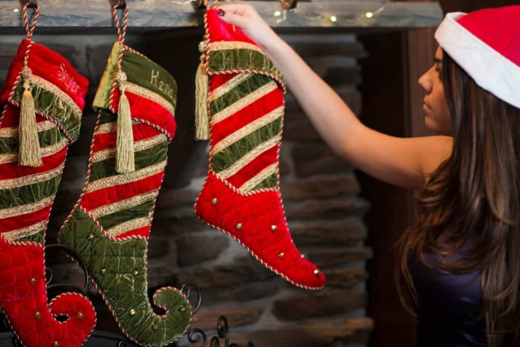 college student hanging stockings with a santa hat on