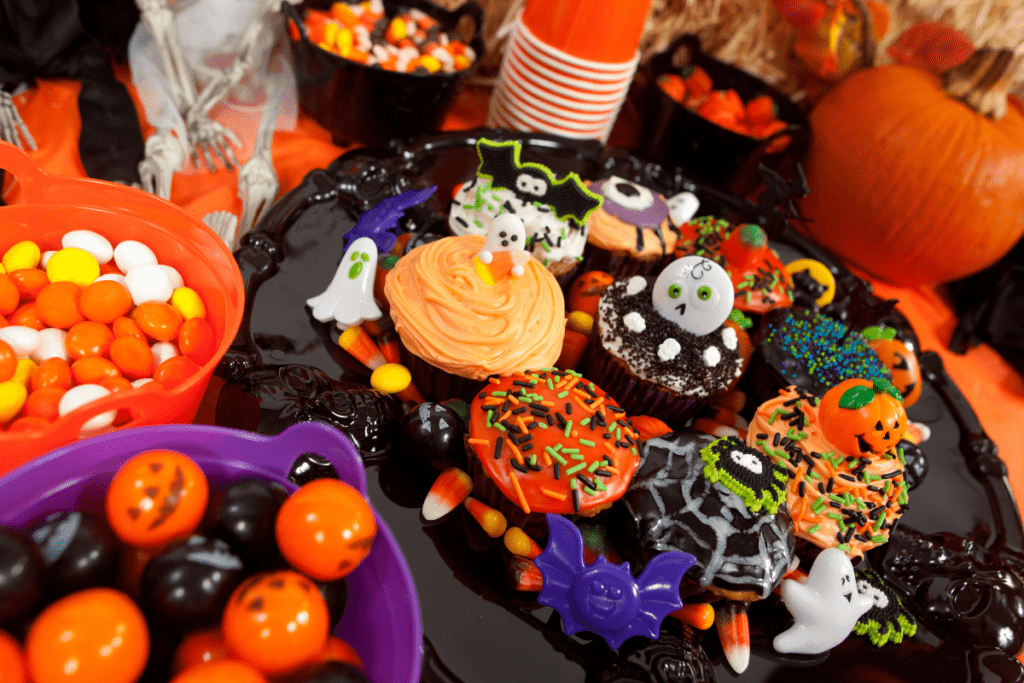 table of halloween themed treats and cupcakes