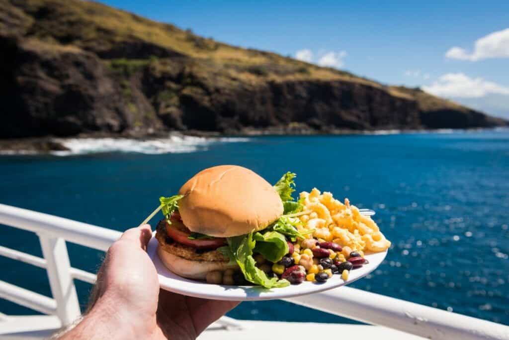chicken sandwich and side of beans on a boat