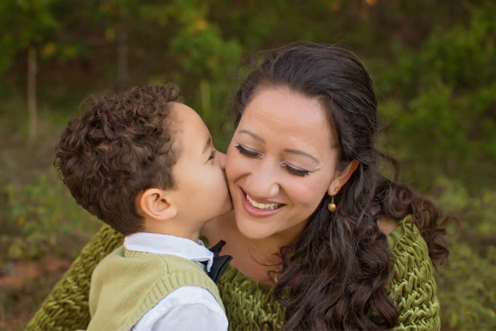 boy kissing his mom on the cheek
