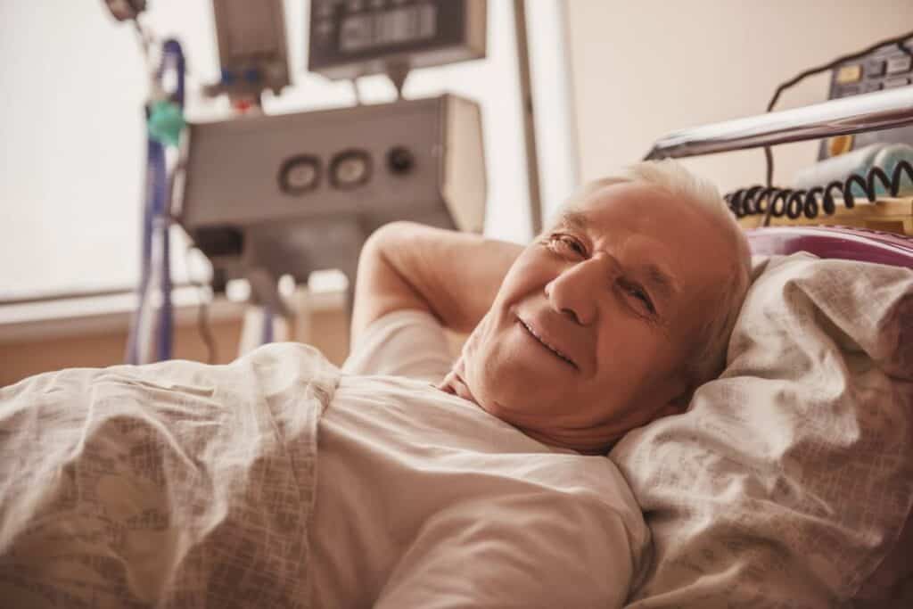 smiling older man in hospital bed