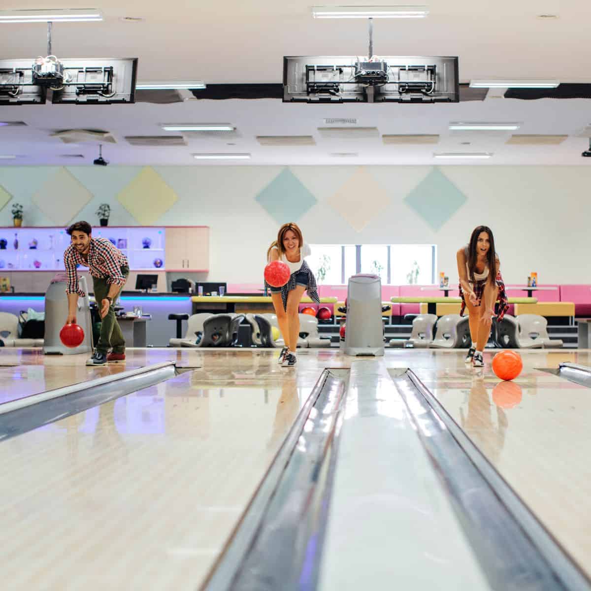 3 friends bowling at a bowling alley