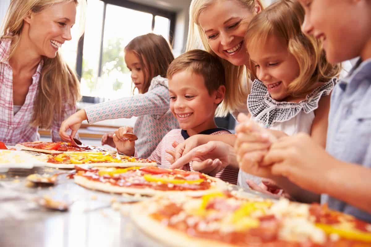kids making pizzas with their adults