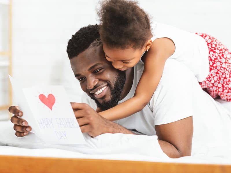 father with his daughter reading a card she made for him