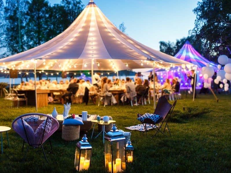 outdoor party tent lit up at dusk