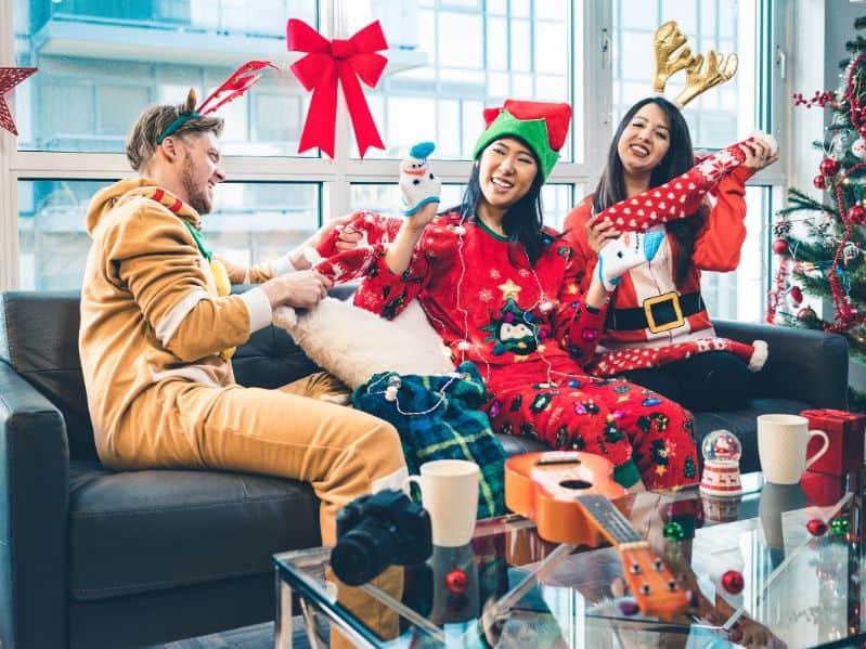 3 friends together in Christmas pajamas after opening presents